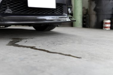 Aracın motor yağı lekeleri araba yol servisi fotoğraf konseptine park edildiğinde arabanın altına sızar.
