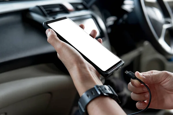 車のオーディオを使用して携帯電話でUsbケーブルを保持する手の女性は プロセス中のデータカーの再生 ナビゲーションシステムと充電モバイルを接続します — ストック写真