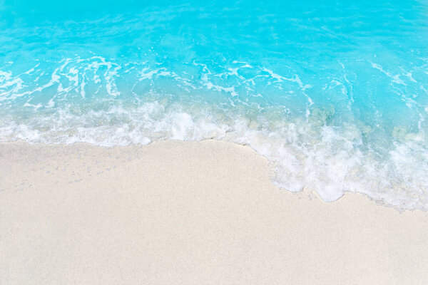 Sea wave and bubble on a sandy white beach blue sea background texture and copy space holiday concept 