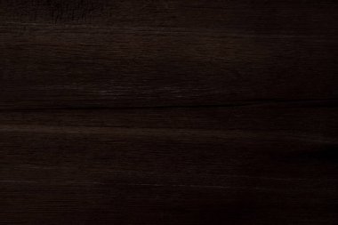 Koyu kahverengi ahşap ve pürüzlü bir yüzeyi var.