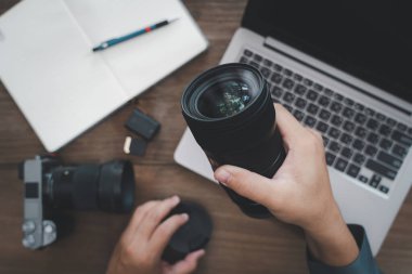 Kameranın lenslerini ve fotoğraf ekipmanlarını eski ahşap masa üzerinde kapatın: fotoğraf işi konsepti