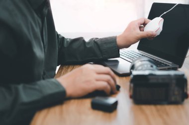 El fotoğrafçısını kapat. Kalibrasyon ve kamera ekranı için dizüstü bilgisayarda renk ayarlama makinesi kullan. Ahşap masadaki pil.