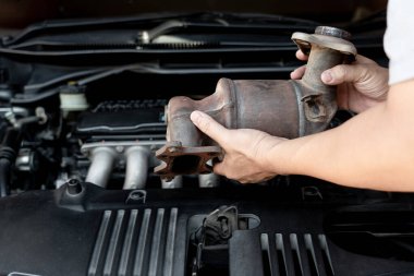 Eldeki eski katalitik dönüştürücüyü kapat. Teknisyen motor benzini tozunu kaldırdı. Servis konseptinde filtrede tıkanmış durumda.