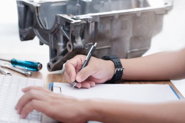 Beyaz kağıt ataç dosyasındaki teknisyen yazıları ve hasarlı eski yağ tavası parçalarını kontrol edin hasarlı motorları ve servis konseptini kontrol edin