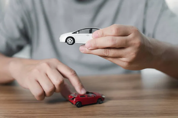 Mężczyzna Trzymać Samochód Zabawki Idealnym Stanie Ręku Porównać Uszkodzone Samochody — Zdjęcie stockowe