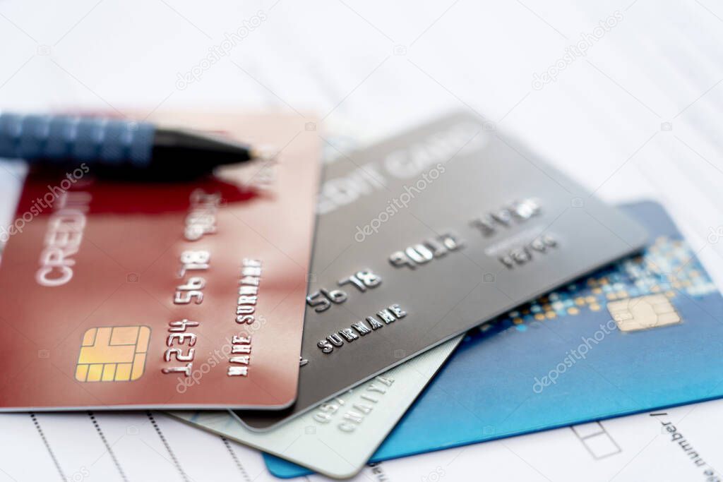 Close up credit cards on insurance document for payment of Annual insurance expenses that must be paid regularly instead of using cash