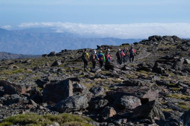 Sierra Nevada 'da bir grup yürüyüşçü alçak bulutlar denizine doğru yürüyor.