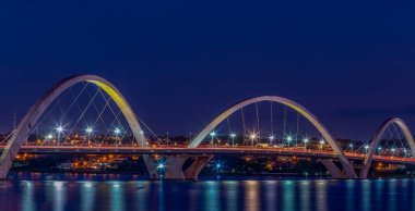 Gölün üzerindeki köprünün gece manzarası. JK Köprüsü. Brezilya 'nın başkenti Brasilia. Mavi saat. Şehir manzarası. Uzun pozlama