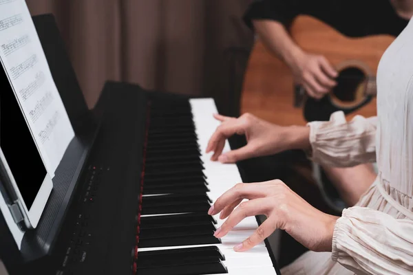 Woman Hand Pressed Paino Keyboard While Her Friend Playing Guitar — Stock Photo, Image