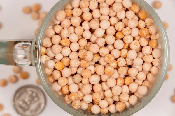 Guisantes amarillos secos redondos en taza de vidrio . — Foto de Stock