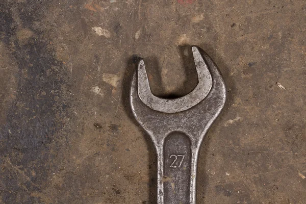 Yerdeki büyük anahtarı. Motor yağı ile kaplı. Garaj araçları.