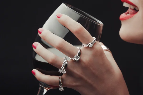 Mujer degustación de vino manos todo en anillos de cerca — Foto de Stock