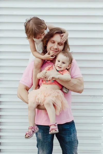 Young father with two daughters in his arms — Stock Photo, Image