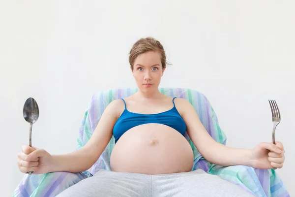 Portrait of young pregnant woman, stomach in focus — Stock Photo, Image