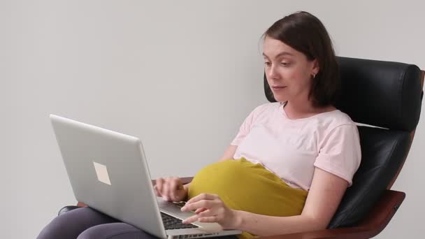 Donna incinta utilizzando il computer portatile — Video Stock