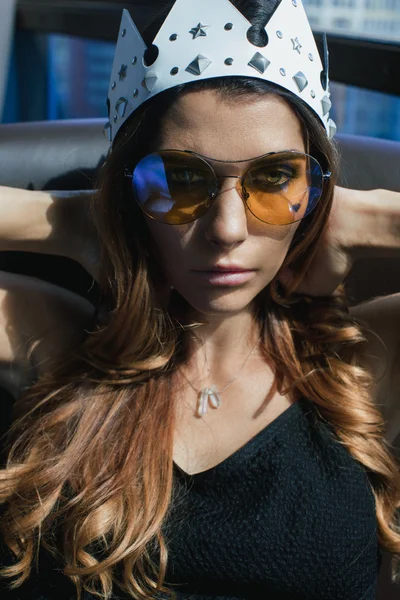 Mladá žena v sluneční brýle a koruna — Stock fotografie