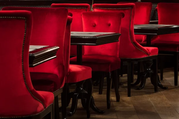 Cadeiras de veludo vermelho e mesas pretas — Fotografia de Stock