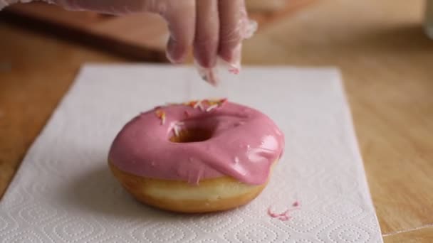 Chef-kok handen strooi poeder roze donut — Stockvideo