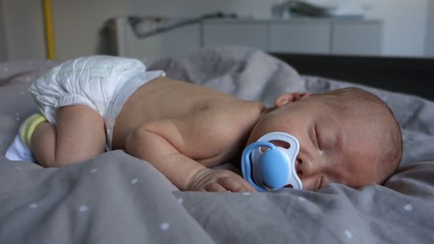 Новонароджена сонна дитина смокче соску — стокове відео