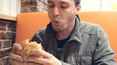 Man çizburger fast food restoranında yemek