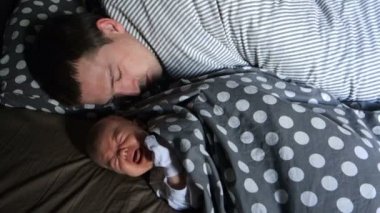 Yeni doğmuş bir bebek uykuda babasıyla yalan ağlar