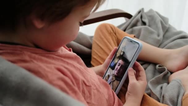 Malý chlapec mluví s otcem pomocí videokalonu na smartphonu — Stock video