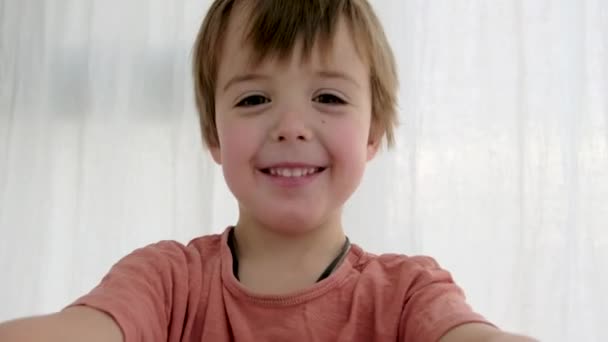 Speels kind maakt hart met vingers als frame op camera — Stockvideo
