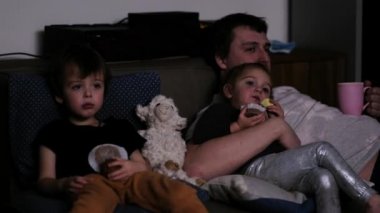 Evde çizgi film izleyen aile.