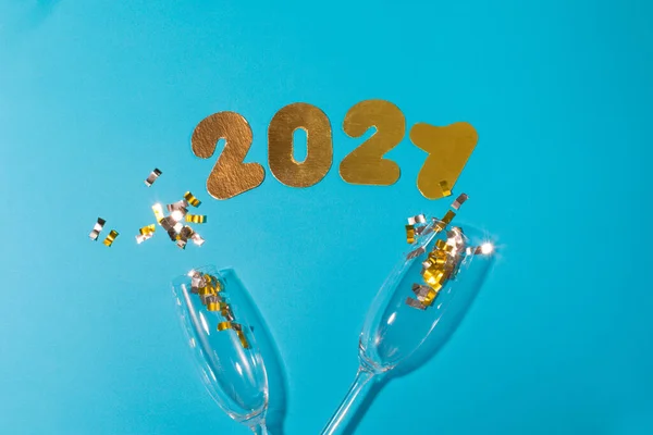 Numerele 2021 pe un fundal albastru cu pahare de sampanie si bomboane — Fotografie, imagine de stoc