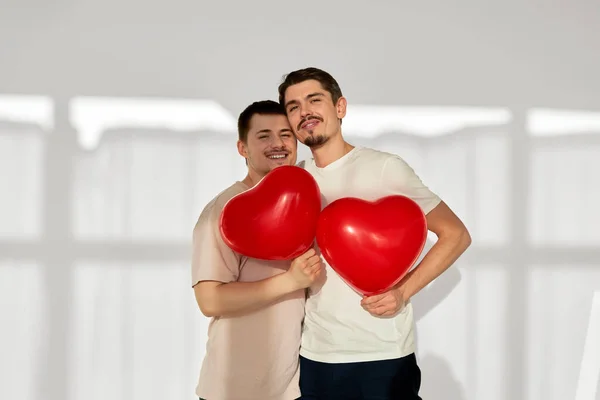 Gay pareja de hombres con globos en la forma de los corazones —  Fotos de Stock