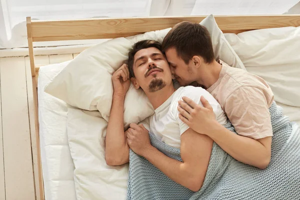 Feliz pareja gay acostada en la cama en casa —  Fotos de Stock