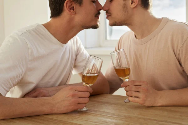 一对同性恋夫妇用杯子喝酒，亲吻 — 图库照片