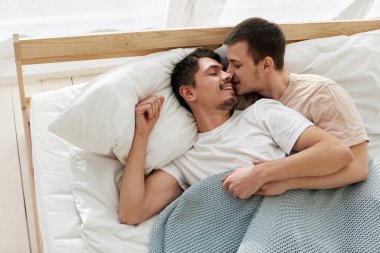 Mutlu eşcinsel çift evde yatakta yatıyor.