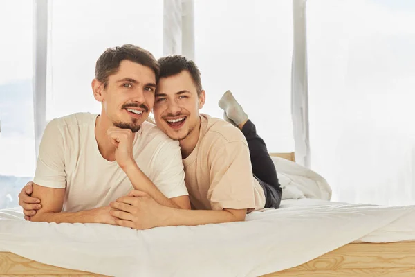 Щаслива гей пара відпочиває на ліжку — стокове фото