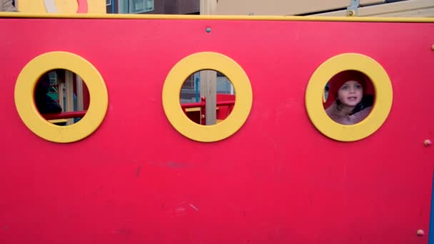Kleine Kinder spielen in rotem und gelbem Labyrinth auf Spielplatz — Stockvideo