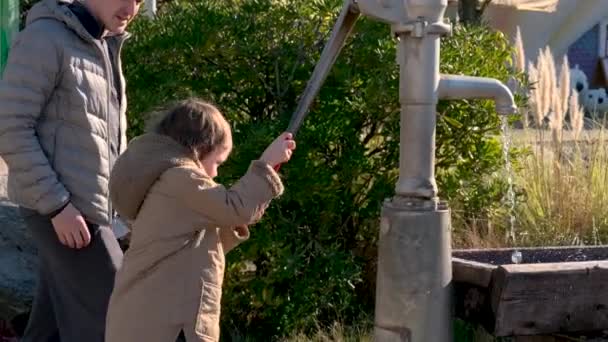 Ragazzo pompe acqua con attrezzature vintage nel cortile della casa del villaggio — Video Stock