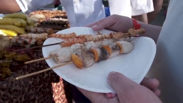 Man houdt bord met exotische schaal-en schelpdieren kebobs in de buurt cafe display — Stockvideo