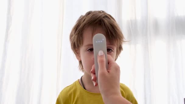 Utilizarea termometrului infraroșu pentru a măsura temperatura corpului copilului — Videoclip de stoc