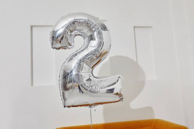 Beyaz duvara yaslanmış iki yıllık balon.