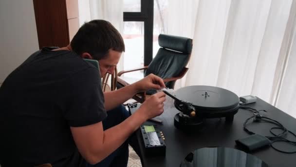 El hombre con teléfono instala la aguja en el cartucho del tocadiscos — Vídeos de Stock