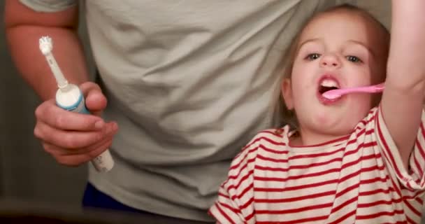 Чищення батьків зубів дітям — стокове відео