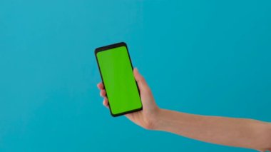 Yeşil ekranlı akıllı telefonu tutan kadın.