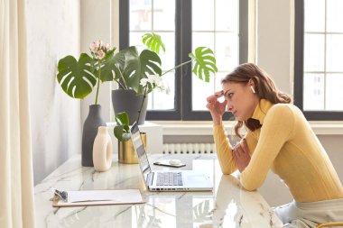 Evde proje üzerinde düşünmekten yorulmuş kadın serbest yazar.