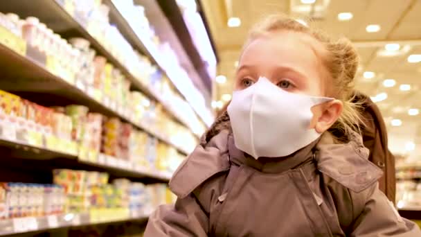 Portret van een meisje met een beschermend masker in een winkel — Stockvideo