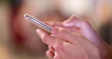 Bulanık arkaplanda akıllı telefonu olan eller