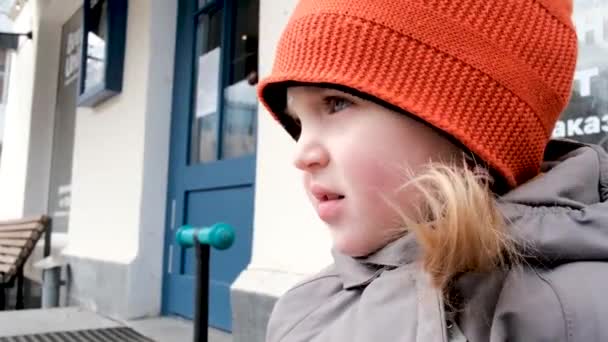 Αγχώδης κοριτσάκι με πορτοκαλί καπέλο περιμένει τη μητέρα από το κατάστημα — Αρχείο Βίντεο