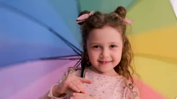 Menina com pães espaço fala com câmera jogando com guarda-chuva — Vídeo de Stock