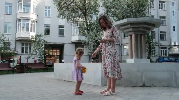 Mère et fille quittent la cour de l'immeuble de grande hauteur — Video