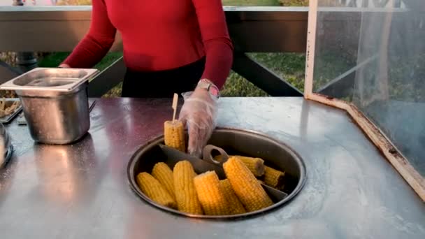 Vendedor de comida de rua polvilhe sal em espiga de milho cozida na hora — Vídeo de Stock