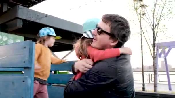 Ώριμος πατέρας με γυαλιά ηλίου αγκαλιάζει την κόρη του φορώντας καπέλο. — Αρχείο Βίντεο